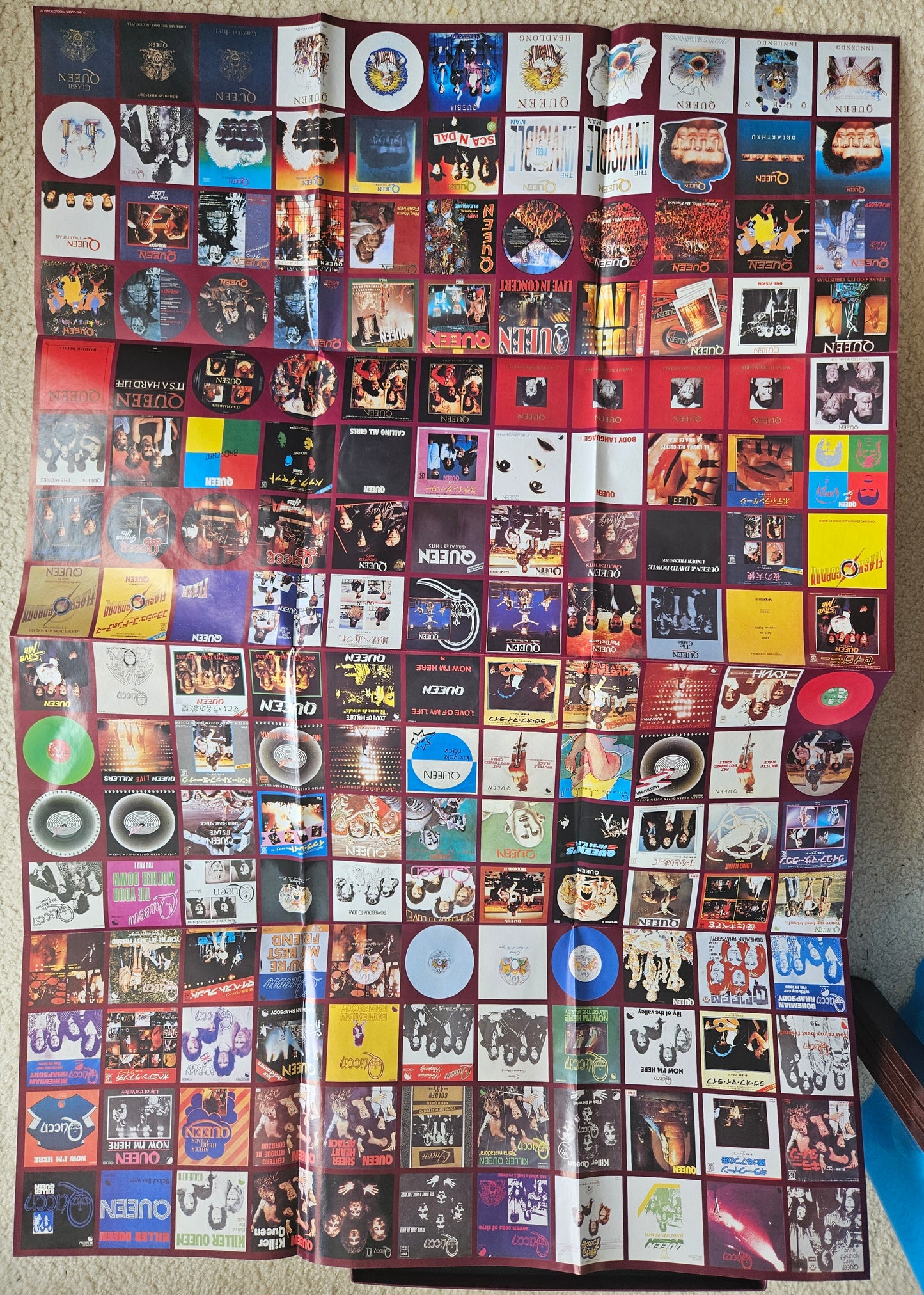 Large collection of compact disc covers displayed on a flat surface.