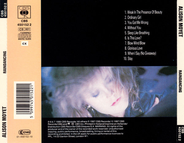 Back cover of a CBS Records CD release for Alison Moyet's 'Rain Dancing', showing tracklist text on a black background with a blurred portrait of the artist and a beige spine band.