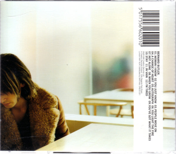 The back cover of a Bernard Butler CD single, featuring a tracklist on the right side and a blurred photograph of a person in a brown fur coat on the left.