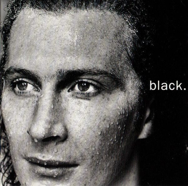 A close-up black and white portrait of a man's face with the word 'black.' printed in white on the right side.