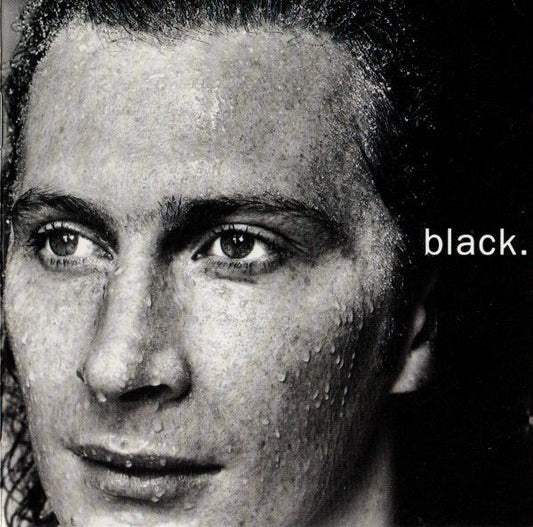 A close-up black and white portrait of a man's face with the word 'black.' printed in white on the right side.