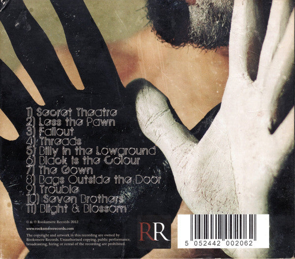 Back cover of a music album featuring a close-up of a person's face with black and white painted hands, a track list on the left, and a barcode at the bottom right.