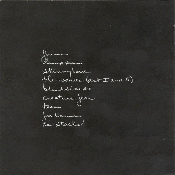 A black square card or print featuring white handwritten text listing song titles and names, including 'Home', 'Thump sin', 'Skinny love', 'The wolves (Act I and II)', 'Blindside', 'Creature fear', 'For Emma', and 'Le: Attack'.