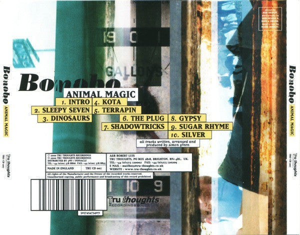 Bonobo's 'Animal Magic' CD album cover, featuring a collage-style background of weathered wooden posts and blue-toned light with a tracklist overlaid in yellow boxes.