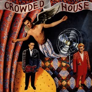 Album cover art for Crowded House's 'Crowded House', featuring a surreal collage with a shirtless winged figure, two band members, a large fan, and the band's name in a banner at the top.