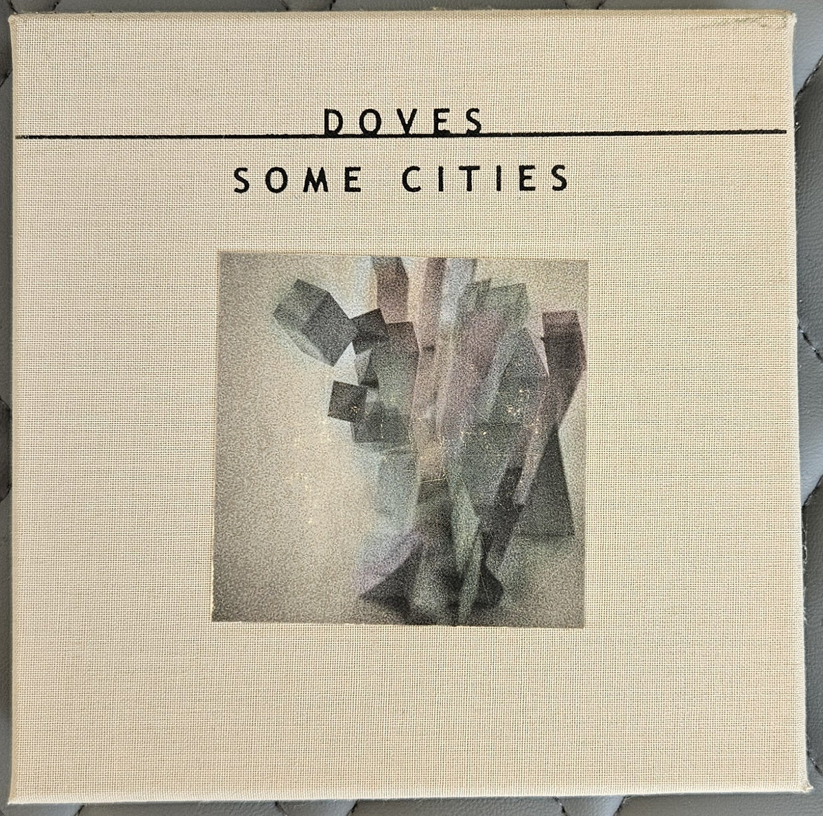 A square canvas print of the album cover for Doves - Some Cities, featuring a textured cream linen background with black text and a central abstract geometric artwork.