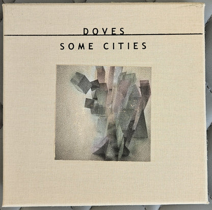 A square canvas print of the album cover for Doves - Some Cities, featuring a textured cream linen background with black text and a central abstract geometric artwork.