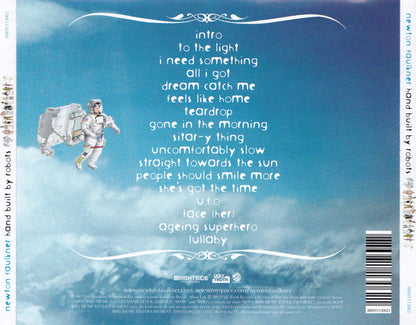 The back cover of the Newton Faulkner album 'Hand built by robots', featuring a light blue sky and clouds background with a white astronaut illustration on the left. The tracklist is printed in white text, and a barcode is visible on the right spine.