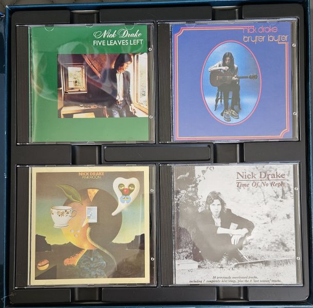 A 4-pack of Nick Drake CD albums arranged in a black plastic tray. The albums are 'Five Leaves Left' (green), 'Bryer Butler' (blue), 'Surrender' (yellow-brown), and 'Time of My Life' (black and white).