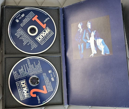 A used CD case for the band 'The Police' 'Police' album, showing two CD-ROMs in the black foam insert and the open blue jewel case cover with a photo of the band members.