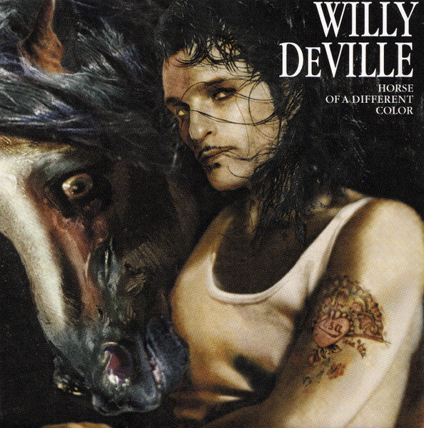 Album cover art for Willy Deville's 'Horse of a Different Color', featuring a painted portrait of a woman in a white tank top next to a horse, with the artist's name and album title in white text at the top right.