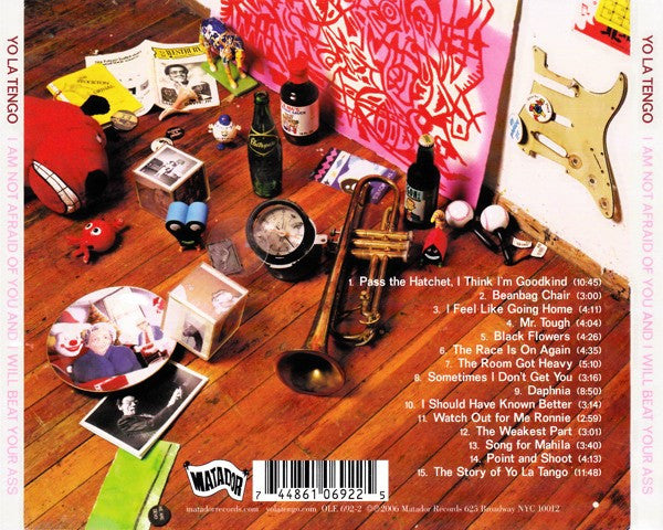 Album cover with musical instruments and objects on a wooden surface, featuring text and a barcode.