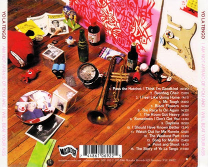 Album cover with musical instruments and objects on a wooden surface, featuring text and a barcode.