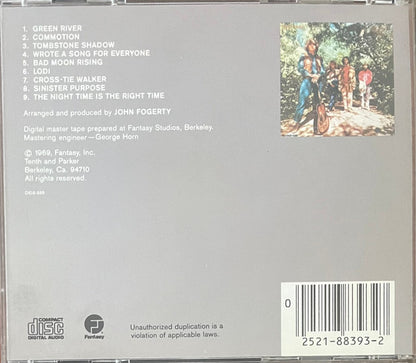 Back cover of a CD album for 'Green River' by John Fogerty, featuring a gray background, tracklist on the left, a small illustrated cover photo on the right, and a barcode in the bottom right corner.